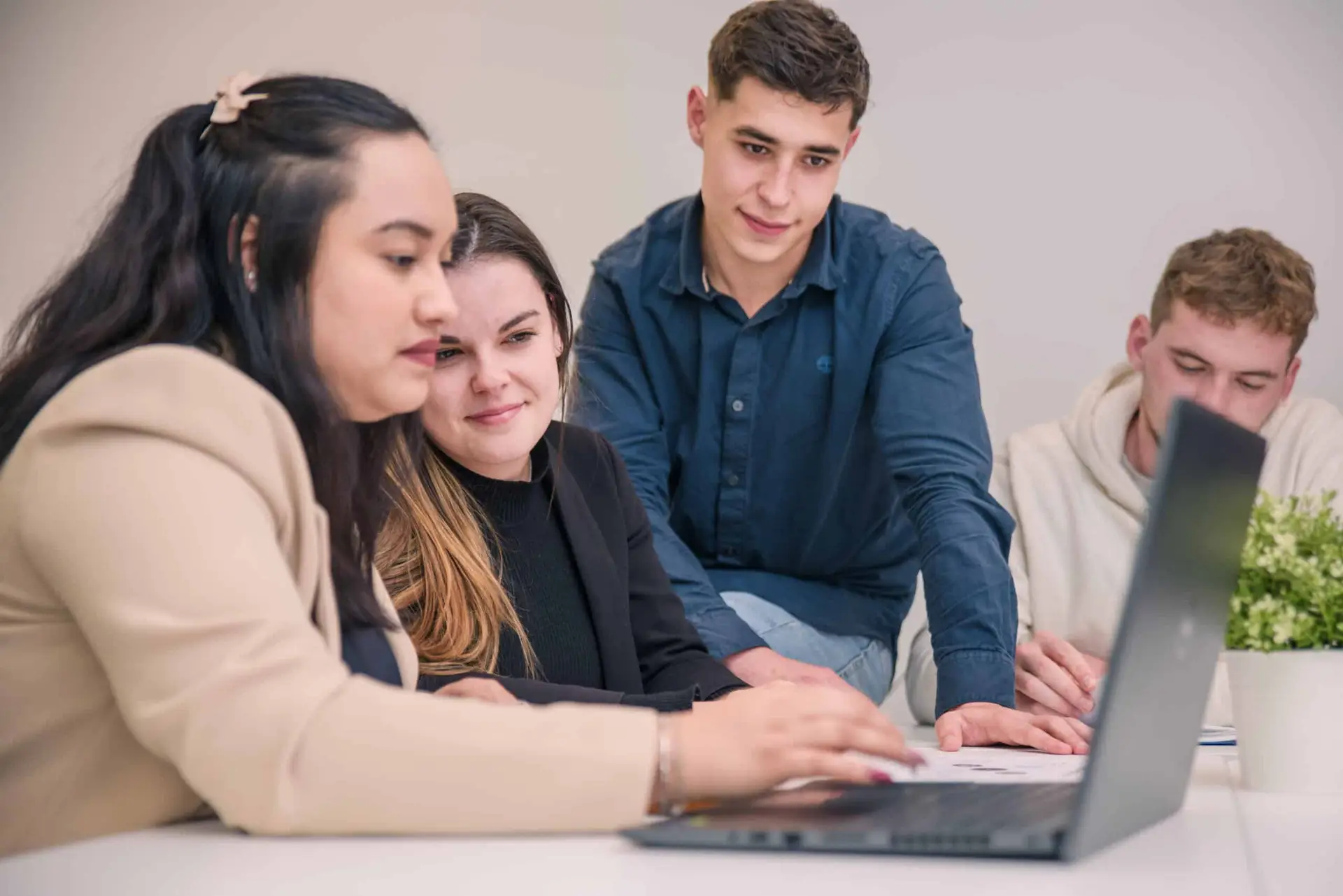 VIGNETTE – BACH BFA Photo de quatre étudiants dont un assis sur la table, travaillant ensemble sur un ordinateur